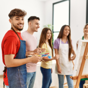 Group of people smiling happy drawing on canvas standing at art studio.